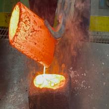 Hot liquid metal being poured for refinement